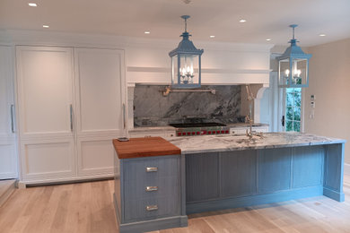 Eat-in kitchen - huge coastal galley light wood floor and brown floor eat-in kitchen idea in Other with an undermount sink, recessed-panel cabinets, white cabinets, marble countertops, multicolored backsplash, marble backsplash, stainless steel appliances, an island and multicolored countertops