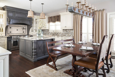 Design ideas for a mid-sized traditional u-shaped eat-in kitchen in Atlanta with with island, a farmhouse sink, raised-panel cabinets, white cabinets, multi-coloured splashback, mosaic tile splashback, stainless steel appliances, dark hardwood floors, brown floor and granite benchtops.