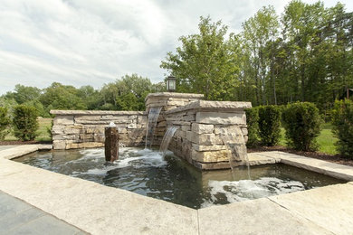 Design ideas for a modern backyard formal garden in Toronto with a water feature.