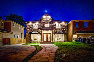 Large transitional gray two-story stone exterior home idea in Toronto with a shingle roof