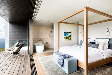 Design ideas for a beach style master bedroom in Sydney with white walls, light hardwood floors and beige floor.