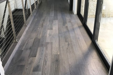 Photo of a large modern hallway in Tampa with white walls, medium hardwood floors and grey floor.