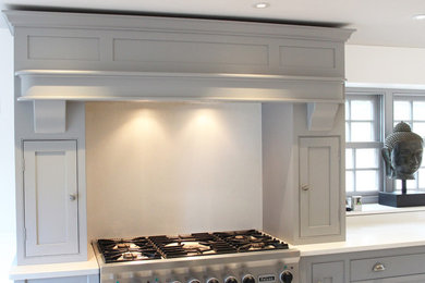 This is an example of a traditional l-shaped kitchen/diner in Other with shaker cabinets, quartz worktops and an island.