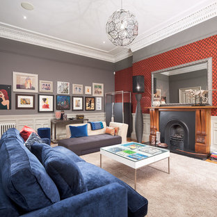 This is an example of an eclectic living room in Glasgow with grey walls, carpet, a standard fireplace, a metal fireplace surround and beige floors.