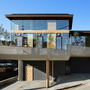 他の地域のコンテンポラリースタイルのおしゃれな家の外観 (ガラスサイディング、マルチカラーの外壁、陸屋根) の写真