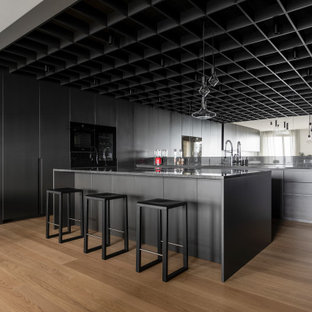 Esempio di un'ampia cucina moderna con lavello da incasso, ante lisce, top in granito, paraspruzzi nero, paraspruzzi in granito, elettrodomestici neri, parquet chiaro, top nero, soffitto a cassettoni, ante grigie e pavimento beige