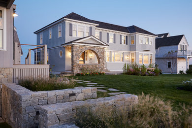 Beach style two-storey grey house exterior in Portland Maine with wood siding, a hip roof and a shingle roof.