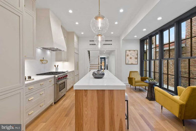 Kitchen - large transitional light wood floor kitchen idea in DC Metro with an undermount sink, shaker cabinets, beige cabinets, marble countertops, marble backsplash, stainless steel appliances, an island and white countertops