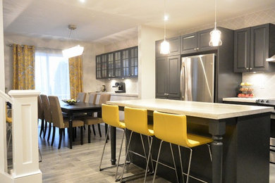 Large transitional l-shaped kitchen photo in Montreal with raised-panel cabinets, gray cabinets, gray backsplash, stainless steel appliances and an island