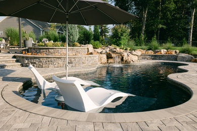 Mountain style backyard concrete paver and custom-shaped pool photo in Richmond