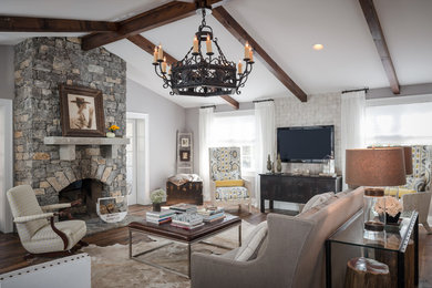 Example of a large classic open concept dark wood floor and brown floor living room design in Nashville with gray walls, a standard fireplace, a stone fireplace and a wall-mounted tv