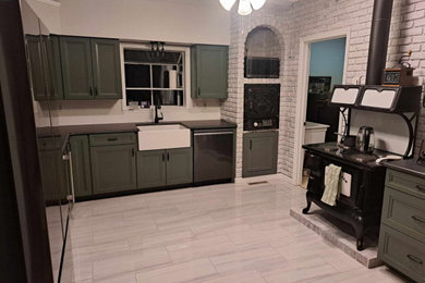Example of a large farmhouse u-shaped porcelain tile kitchen design in DC Metro with a farmhouse sink, recessed-panel cabinets, quartz countertops, black appliances and black countertops