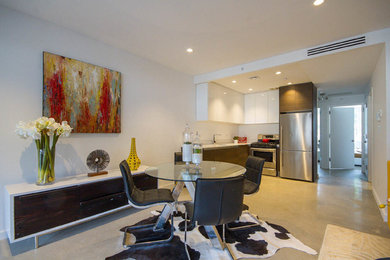 Mid-sized trendy concrete floor and gray floor kitchen/dining room combo photo in New York with white walls and no fireplace