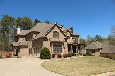 Inspiration for a large timeless brown two-story brick house exterior remodel in Atlanta with a hip roof and a shingle roof