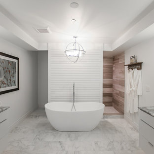 Esempio di una grande stanza da bagno padronale minimalista con ante lisce, ante bianche, vasca freestanding, doccia aperta, WC a due pezzi, piastrelle beige, piastrelle bianche, pareti bianche, pavimento in marmo, lavabo sottopiano, top in marmo e piastrelle in pietra