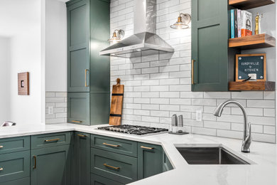 Mid-sized transitional l-shaped enclosed kitchen photo in Detroit with flat-panel cabinets, green cabinets, quartz countertops, white backsplash, porcelain backsplash, a peninsula and white countertops