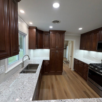 USCD cabinetry accompanied granite countertops, porcelain tile backsplash and Ca