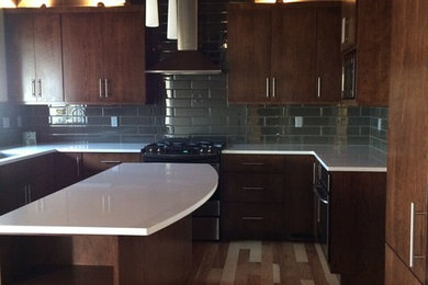 Mid-sized midcentury u-shaped eat-in kitchen in Seattle with an undermount sink, flat-panel cabinets, brown cabinets, quartzite benchtops, grey splashback, porcelain splashback, stainless steel appliances, light hardwood floors and with island.