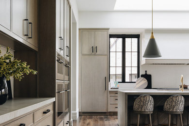 Inspiration for a contemporary brown floor eat-in kitchen remodel in Chicago with light wood cabinets, white backsplash, an island and white countertops