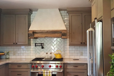 Eat-in kitchen - traditional u-shaped eat-in kitchen idea in Denver with recessed-panel cabinets, medium tone wood cabinets, marble countertops, white backsplash, subway tile backsplash and stainless steel appliances