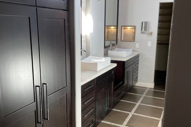 Inspiration for a mid-sized transitional gray tile and limestone tile mosaic tile floor, gray floor, double-sink and vaulted ceiling bathroom remodel in Dallas with shaker cabinets, dark wood cabinets, a two-piece toilet, gray walls, a pedestal sink, quartzite countertops, white countertops, a niche and a built-in vanity