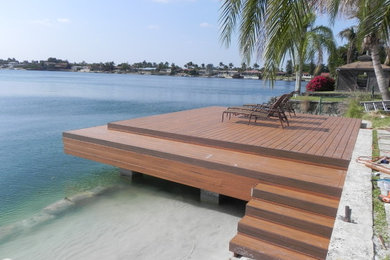 Design ideas for a mid-sized beach style backyard deck in Miami with with dock and no cover.