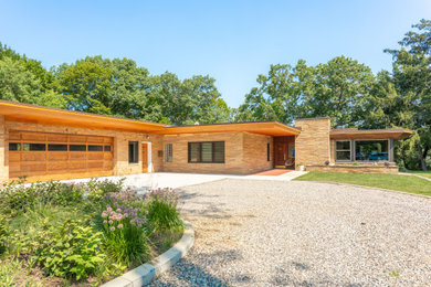 Inspiration for a mid-century modern one-story brick house exterior remodel in Detroit