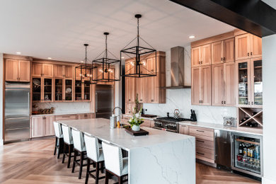 Inspiration for a huge contemporary l-shaped light wood floor and exposed beam eat-in kitchen remodel in Chicago with a farmhouse sink, shaker cabinets, light wood cabinets, quartz countertops, white backsplash, quartz backsplash, stainless steel appliances, an island and white countertops