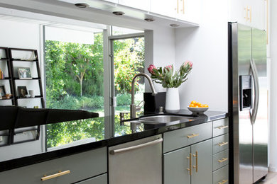 Mid-sized 1950s galley light wood floor and white floor eat-in kitchen photo in San Francisco with an undermount sink, flat-panel cabinets, green cabinets, quartz countertops and stainless steel appliances