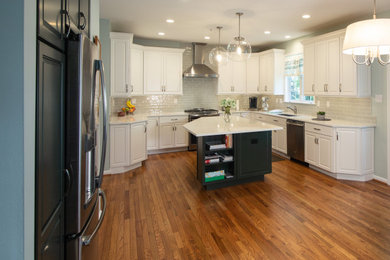 Open concept kitchen - large transitional u-shaped medium tone wood floor and brown floor open concept kitchen idea in Philadelphia with an undermount sink, white cabinets, quartz countertops, gray backsplash, ceramic backsplash, stainless steel appliances, an island and white countertops