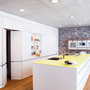 Large modern kitchen pantry ideas - Large minimalist medium tone wood floor kitchen pantry photo in Stuttgart with a double-bowl sink, flat-panel cabinets, white cabinets, paneled appliances and an island