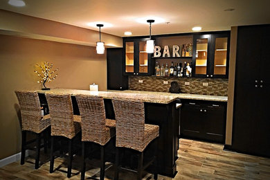 Seated home bar - mid-sized traditional u-shaped porcelain tile seated home bar idea in Chicago with an undermount sink, raised-panel cabinets, dark wood cabinets, granite countertops and glass tile backsplash