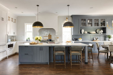 Inspiration for a transitional l-shaped dark wood floor and brown floor eat-in kitchen remodel in Minneapolis with a farmhouse sink, shaker cabinets, gray cabinets, gray backsplash, stainless steel appliances, an island and white countertops