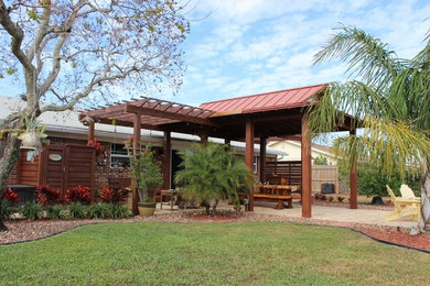 Example of a mid-sized beach style backyard concrete paver outdoor patio shower design in Orlando with a pergola