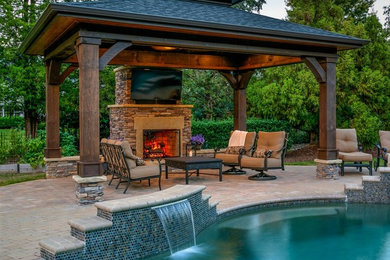 Mid-sized arts and crafts backyard patio in Charlotte with a fire feature, concrete pavers and a gazebo/cabana.