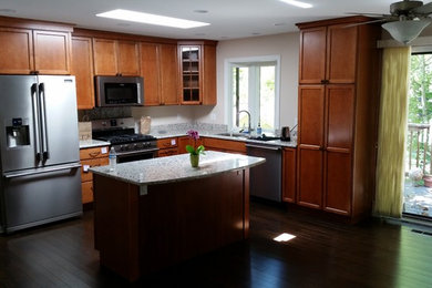Mid-sized trendy l-shaped dark wood floor open concept kitchen photo in Detroit with a double-bowl sink, recessed-panel cabinets, medium tone wood cabinets, granite countertops, beige backsplash, stone slab backsplash, stainless steel appliances and an island