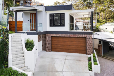 Inspiration for a large contemporary two-storey white house exterior with a flat roof, a metal roof and a white roof.