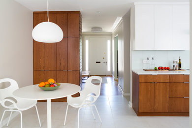 This is an example of a contemporary eat-in kitchen in DC Metro with flat-panel cabinets and medium wood cabinets.
