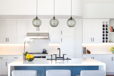 Open concept kitchen - mid-sized contemporary l-shaped medium tone wood floor and brown floor open concept kitchen idea in Orange County with shaker cabinets, white cabinets, quartz countertops, white backsplash, porcelain backsplash, stainless steel appliances, an island, an undermount sink and white countertops