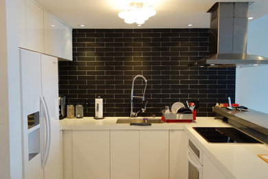 Eat-in kitchen - mid-sized modern u-shaped porcelain tile eat-in kitchen idea in Miami with a double-bowl sink, flat-panel cabinets, white cabinets, quartz countertops, black backsplash, subway tile backsplash, white appliances and a peninsula