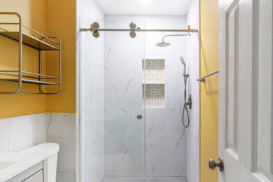 Mid-sized trendy master white tile and porcelain tile porcelain tile, white floor and single-sink bathroom photo in DC Metro with furniture-like cabinets, gray cabinets, a two-piece toilet, yellow walls, an undermount sink, marble countertops, white countertops, a niche and a freestanding vanity