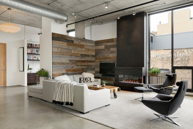 Inspiration for an industrial open concept concrete floor and gray floor living room remodel in Minneapolis with white walls, a ribbon fireplace and a wall-mounted tv