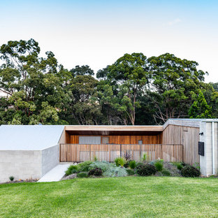 Modern split-level concrete grey house exterior in Gold Coast - Tweed with a flat roof and a metal roof.