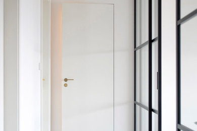 Hallway - mid-sized contemporary light wood floor hallway idea in Denver with white walls