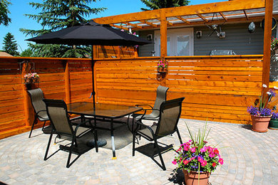 Large transitional backyard brick patio vertical garden photo in Calgary with no cover