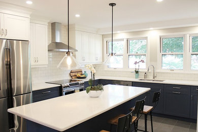 Example of a large transitional l-shaped porcelain tile enclosed kitchen design in Toronto with an undermount sink, recessed-panel cabinets, white cabinets, solid surface countertops, white backsplash, ceramic backsplash, stainless steel appliances and an island