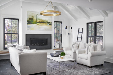 Modelo de sala de estar contemporánea de tamaño medio con paredes blancas, suelo de pizarra, todas las chimeneas, marco de chimenea de metal, televisor colgado en la pared, suelo gris y machihembrado