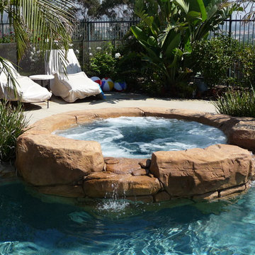 Rock Swimming Pool with Slide, Waterfall and a Table in the pool.