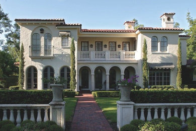 Example of a large tuscan white two-story stucco gable roof design in Orlando