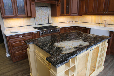 Mid-sized elegant l-shaped medium tone wood floor and gray floor enclosed kitchen photo in Detroit with a farmhouse sink, raised-panel cabinets, medium tone wood cabinets, granite countertops, yellow backsplash, mosaic tile backsplash, stainless steel appliances and an island